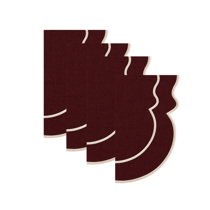 Four dark burgundy fabric coasters with cream-colored wavy borders, arranged in a staggered stack on a solid white background.