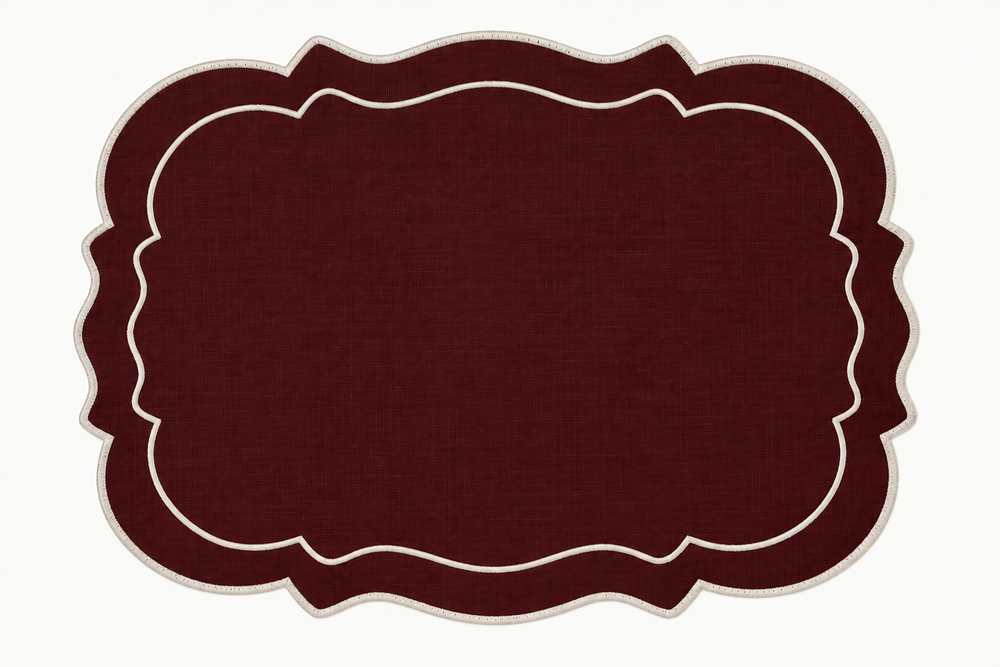 A rectangular placemat with a scalloped border in dark burgundy and cream, shown flat against a white background.