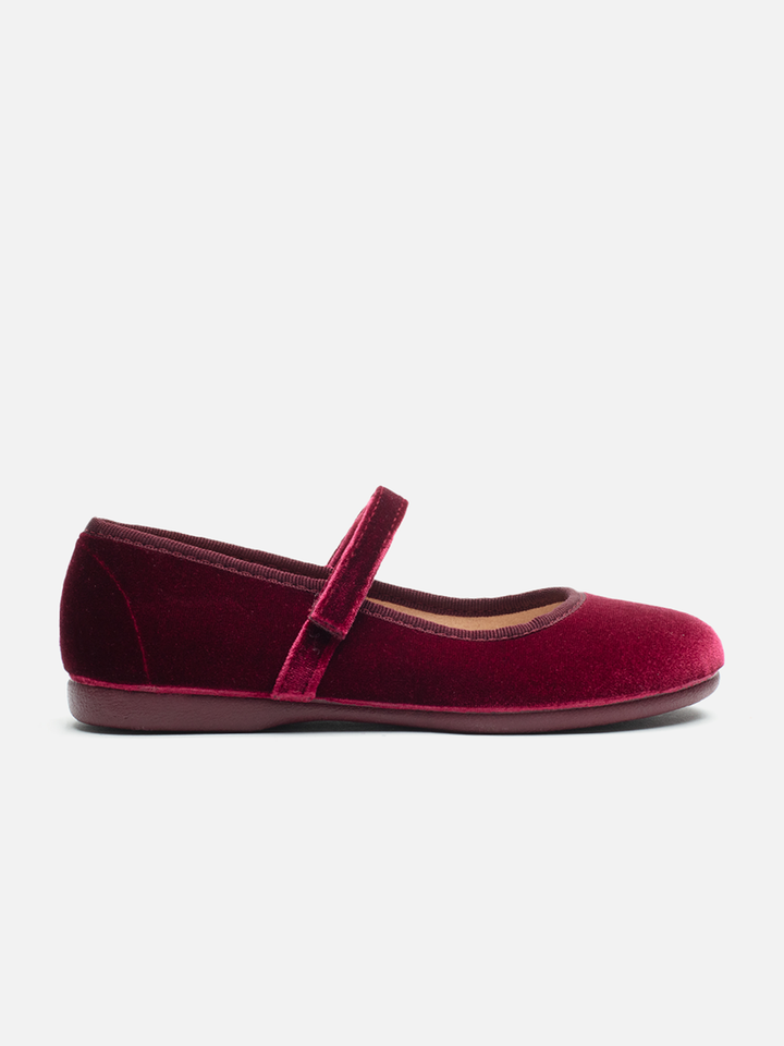 A single burgundy velvet Mary Jane flat shoe with a matching velvet strap, shown in a side profile on a light gray background.
