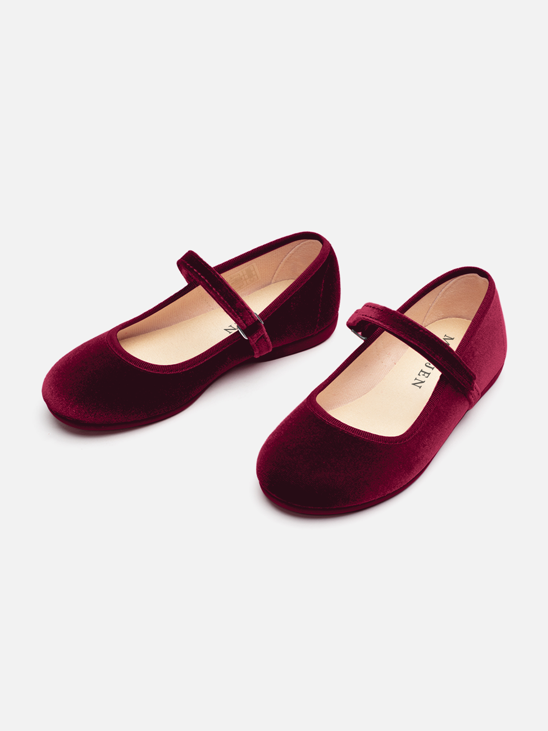 A pair of deep burgundy velvet Mary Jane shoes with a single strap and a small silver buckle, displayed on a clean off-white background.