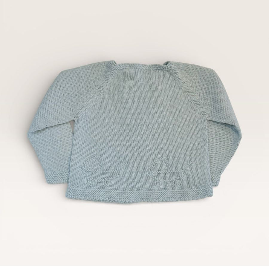 A light blue knit baby sweater with long raglan sleeves and embroidered baby carriages on the front, laid flat against a warm off-white background.