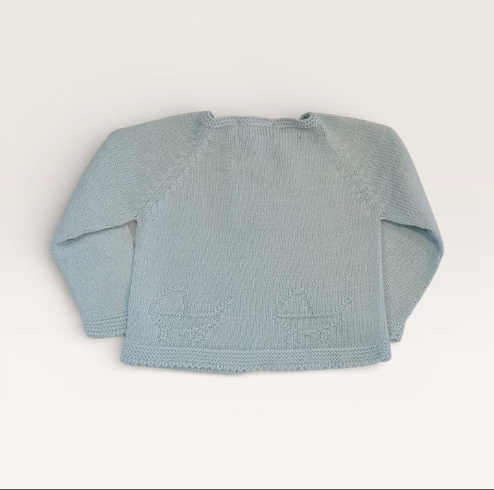 A light blue knit baby sweater with long raglan sleeves and embroidered baby carriages on the front, laid flat against a warm off-white background.