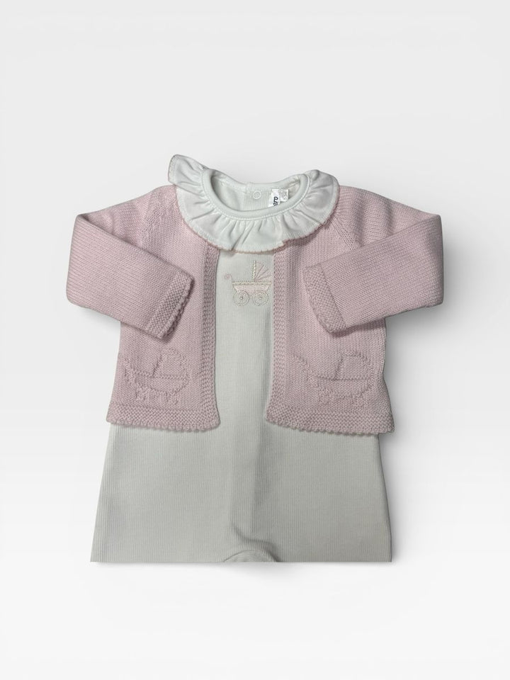 A baby girl's knit cardigan in dusty pink with a ruffled white footie layered 