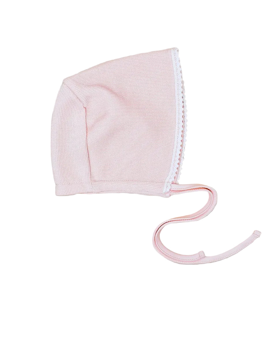 Pink baby bonnet with white trim on a light gray background