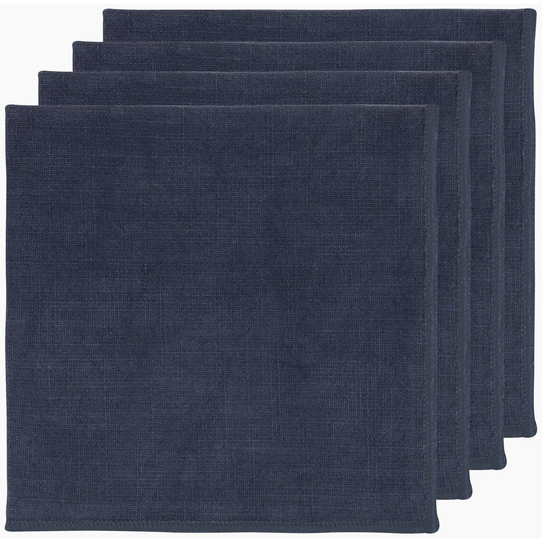 Four navy blue square cloth napkins stacked slightly offset on a plain white background.