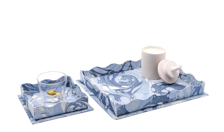 Two blue patterned coasters with a white mug and glass on a white background