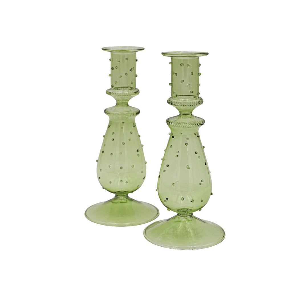 Pair of green glass candle holders with textured design on a white background