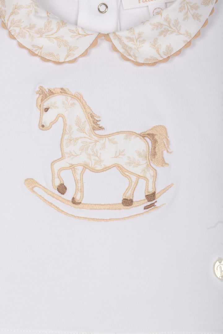 Embroidered rocking horse design on a white shirt with lace collar.