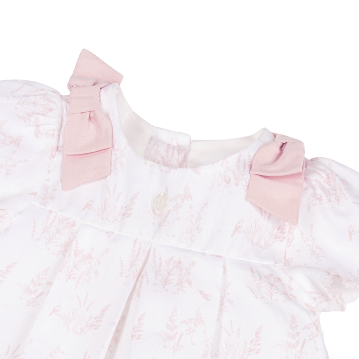 Pink lace dress with bow details on a white background