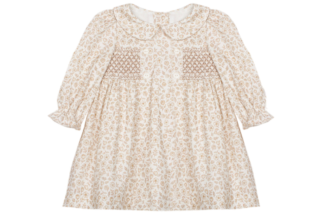 A cream-colored long-sleeve dress with a delicate beige floral pattern, featuring smocked detailing on the chest and a Peter Pan collar, shown against a plain white background.