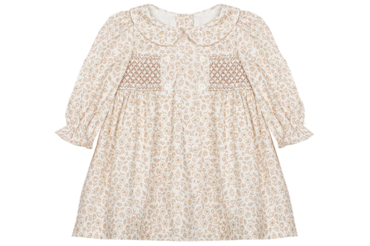 A cream-colored long-sleeve dress with a delicate beige floral pattern, featuring smocked detailing on the chest and a Peter Pan collar, shown against a plain white background.