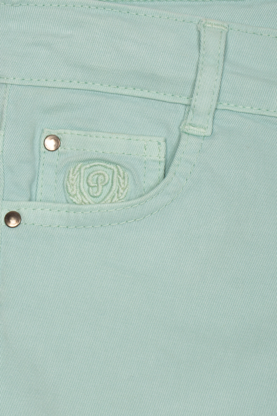 Close-up of a light green chinos with a brand logo and buttons
