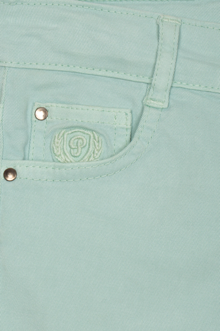 Close-up of a light green chinos with a brand logo and buttons