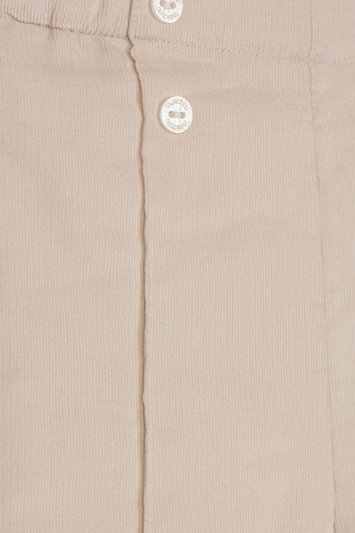 Close-up of a beige ribbed fabric garment with two white buttons on a front placket.