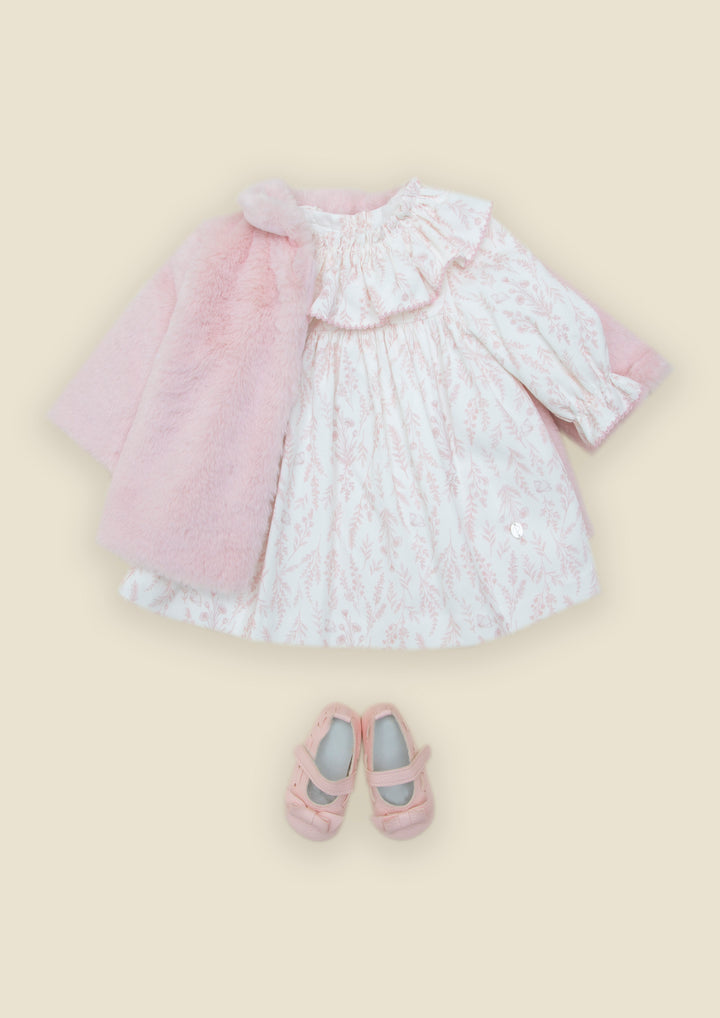 Baby girl floral pink dress paired with a faux fur jacket and pink mary jane shoes laying on a yellow background