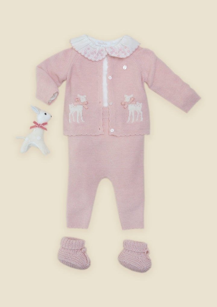 A baby knit outfit set in dusty pink, featuring a long-sleeve cardigan with white deer embroidery, a white ruffled collar, matching pants, booties, and a small white plush toy, all laid out on a light beige background.