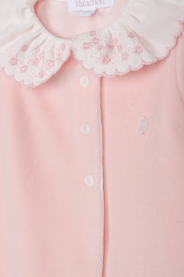 Close-up of a pale pink baby top with a white embroidered Peter Pan collar and white buttons, showing the Patatchou brand label.