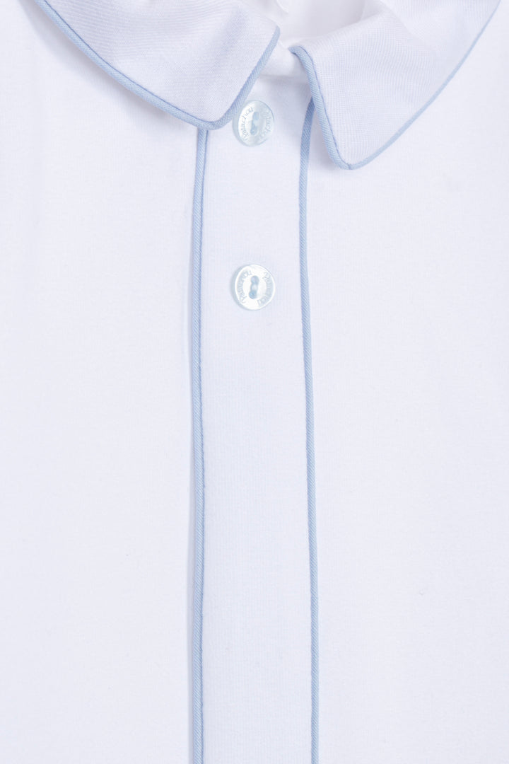 Close-up of a white collared shirt with light blue piping along the collar and placket, featuring white buttons.