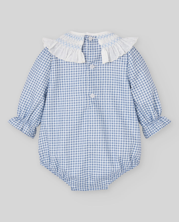 A baby long-sleeve romper in a light blue and white gingham pattern, featuring a white ruffled collar and button details, laid flat on a neutral gray background.