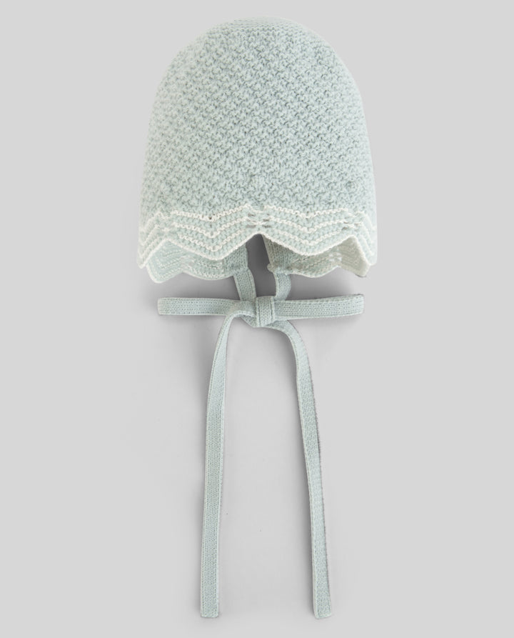 A pale mint green crocheted bonnet hat with a scalloped lace trim and matching ribbon ties, shown against a solid light gray background.
