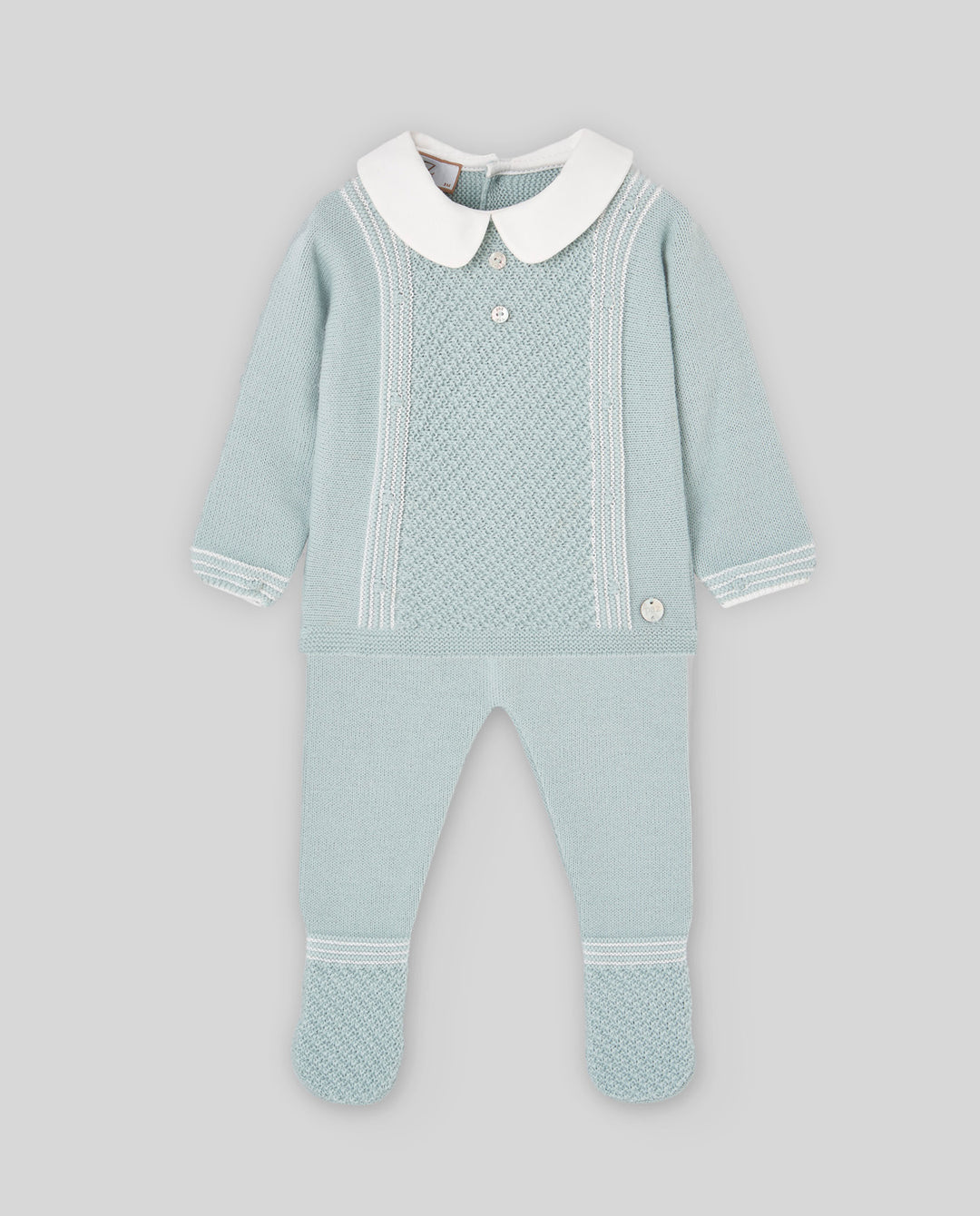 A baby's knit footed one-piece jumpsuit in pale mint green, featuring a contrasting white Peter Pan collar, white button details, and white knit trim on the sleeves and legs, displayed against a solid gray background.