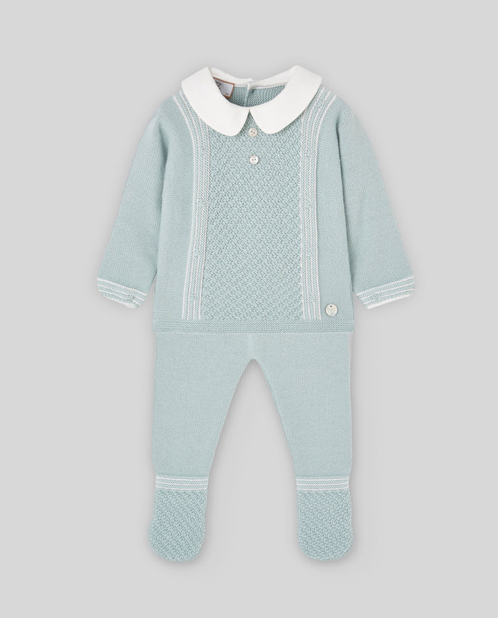 A baby's knit footed one-piece jumpsuit in pale mint green, featuring a contrasting white Peter Pan collar, white button details, and white knit trim on the sleeves and legs, displayed against a solid gray background.
