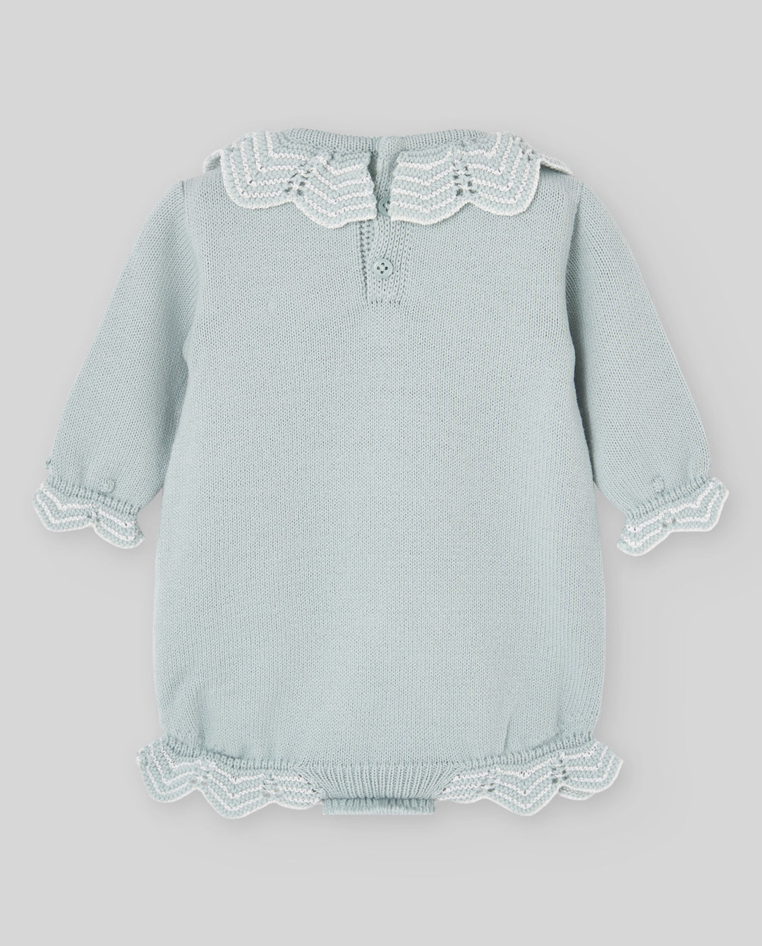 A light sage green baby knit romper with white lace trim on the collar, cuffs, and hem, displayed flat against a neutral gray background.