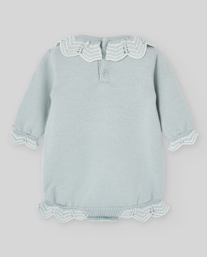 A light sage green baby knit romper with white lace trim on the collar, cuffs, and hem, displayed flat against a neutral gray background.