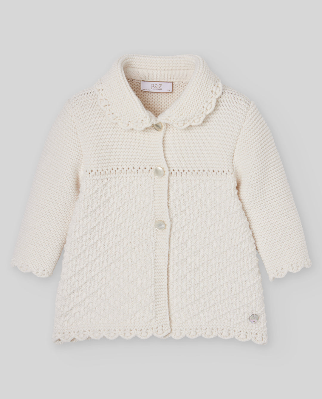 An off-white cream knitted cardigan for toddlers, featuring a Peter Pan collar, scalloped edges, and a front button closure, shown against a neutral gray background.