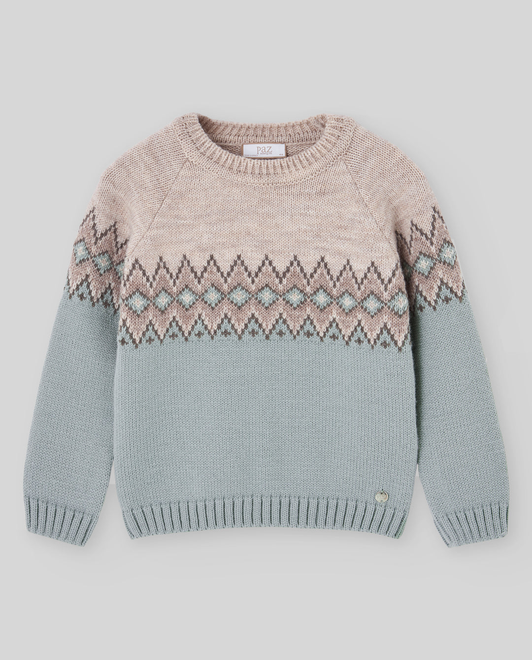 A children's knit sweater with a two-tone design, featuring a light beige upper section and a dusty blue lower section, separated by a geometric Fair Isle pattern band in beige, gray, and light blue.
