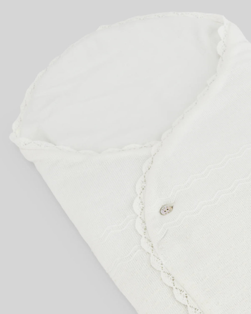 Close up of ivory baby blanket with lace details