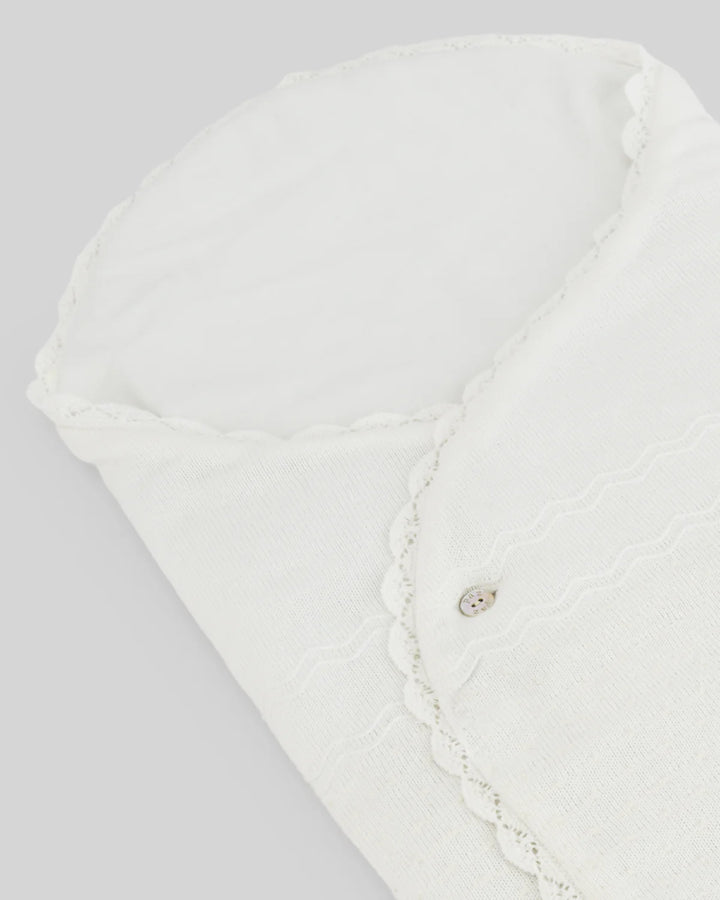 Close up of ivory baby blanket with lace details