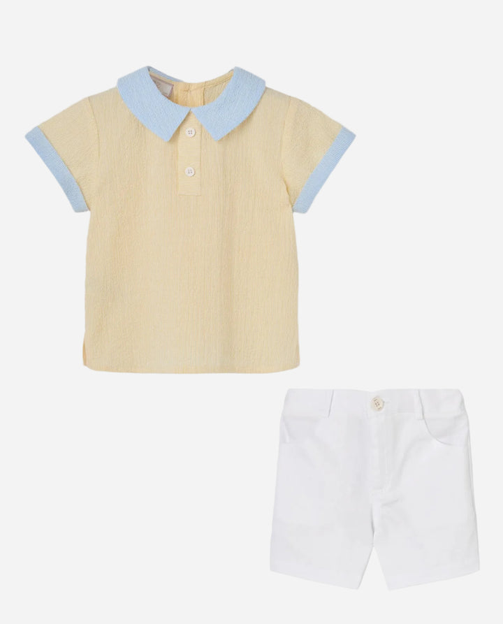 Yellow polo shirt with light blue collar and sleeves, paired with white shorts on a light gray background