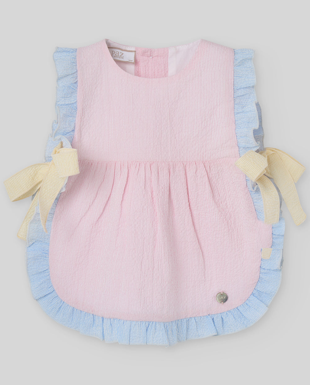 Pink dress with blue trim and yellow accents on a light gray background