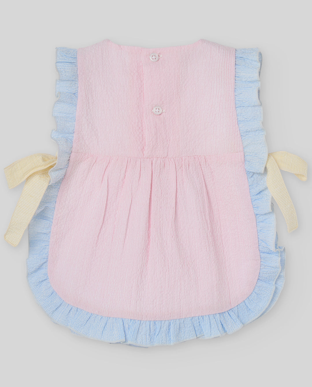 Pink dress with blue ruffles and yellow bows on a light gray background