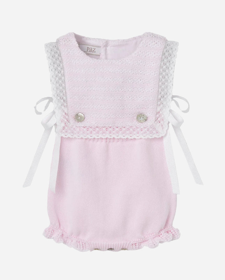 Pink baby romper with lace details on a gray background