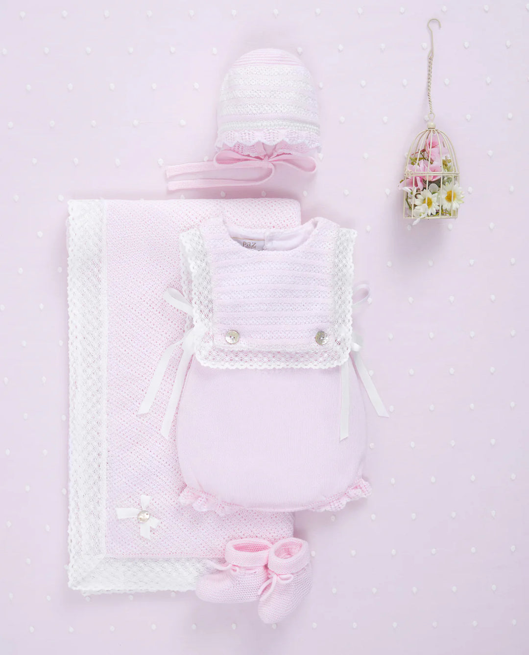 Pink Flatlay of baby girl pink outfit next to flowers