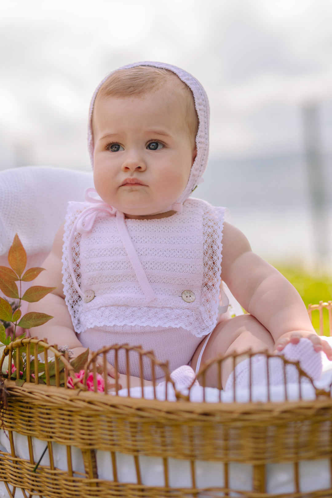 Baby Girl in Pink Romper Outfit in Wicker Basket