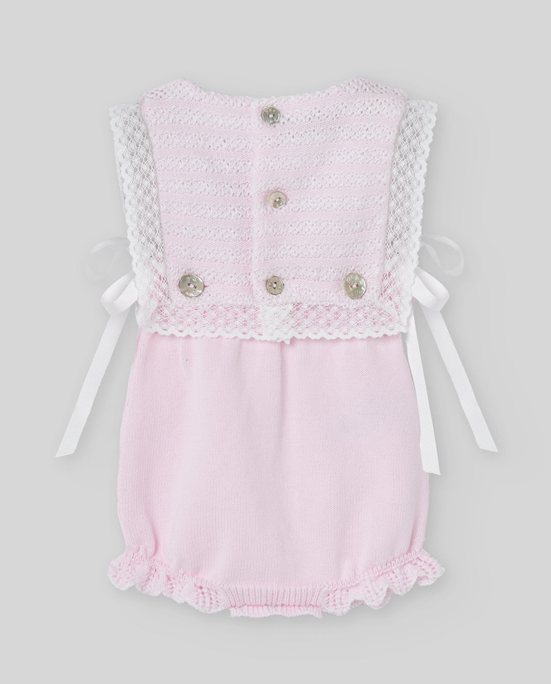 Pink baby romper with lace details on a light gray background