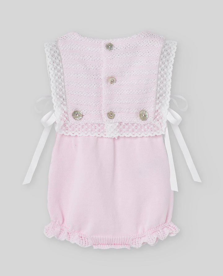 Pink baby romper with lace details on a light gray background