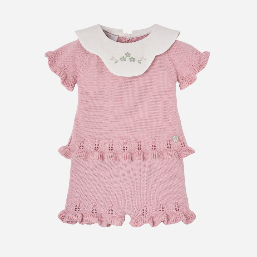 Pink baby romper with white collar on a white background