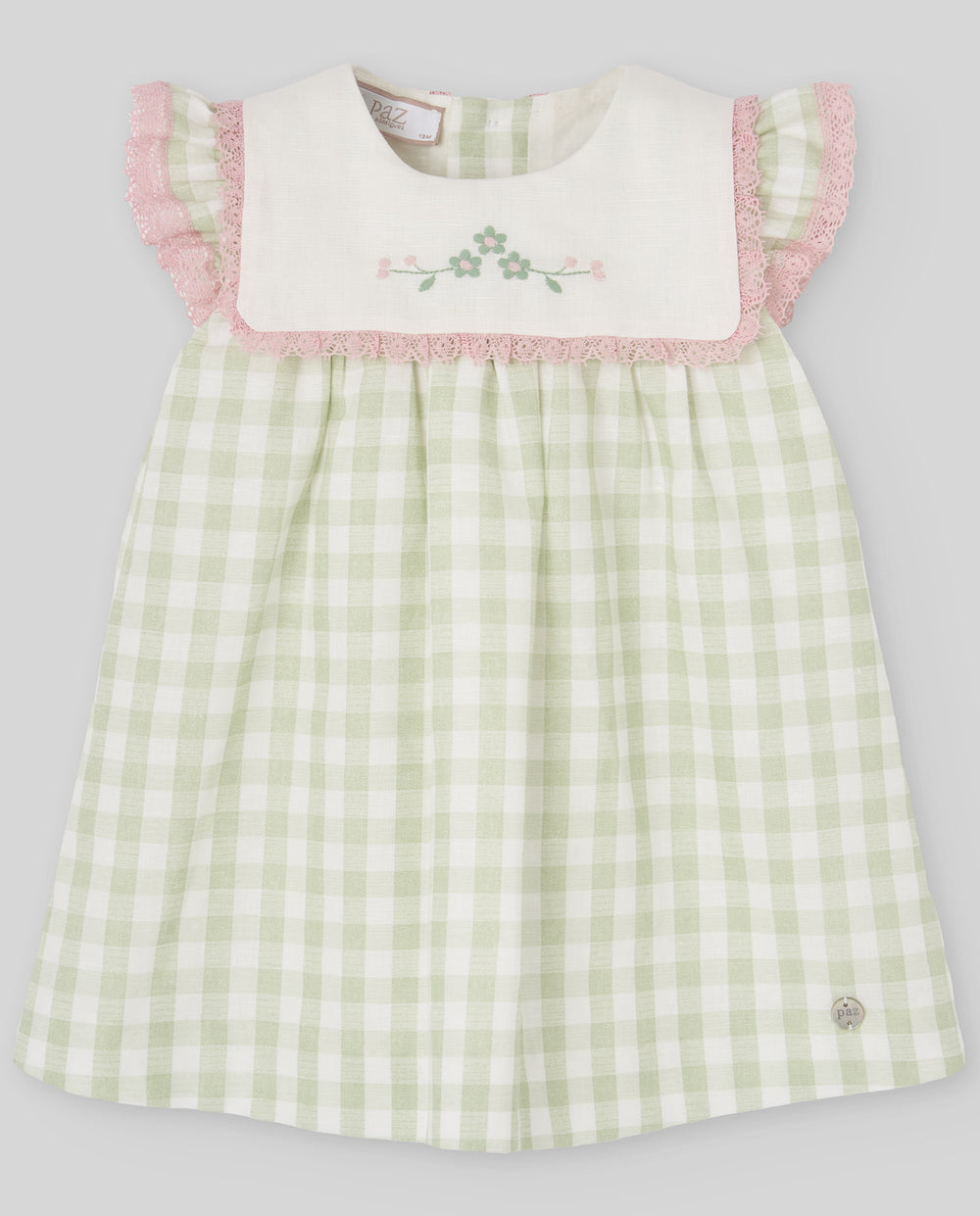 Green checkered dress with pink trim on a light gray background