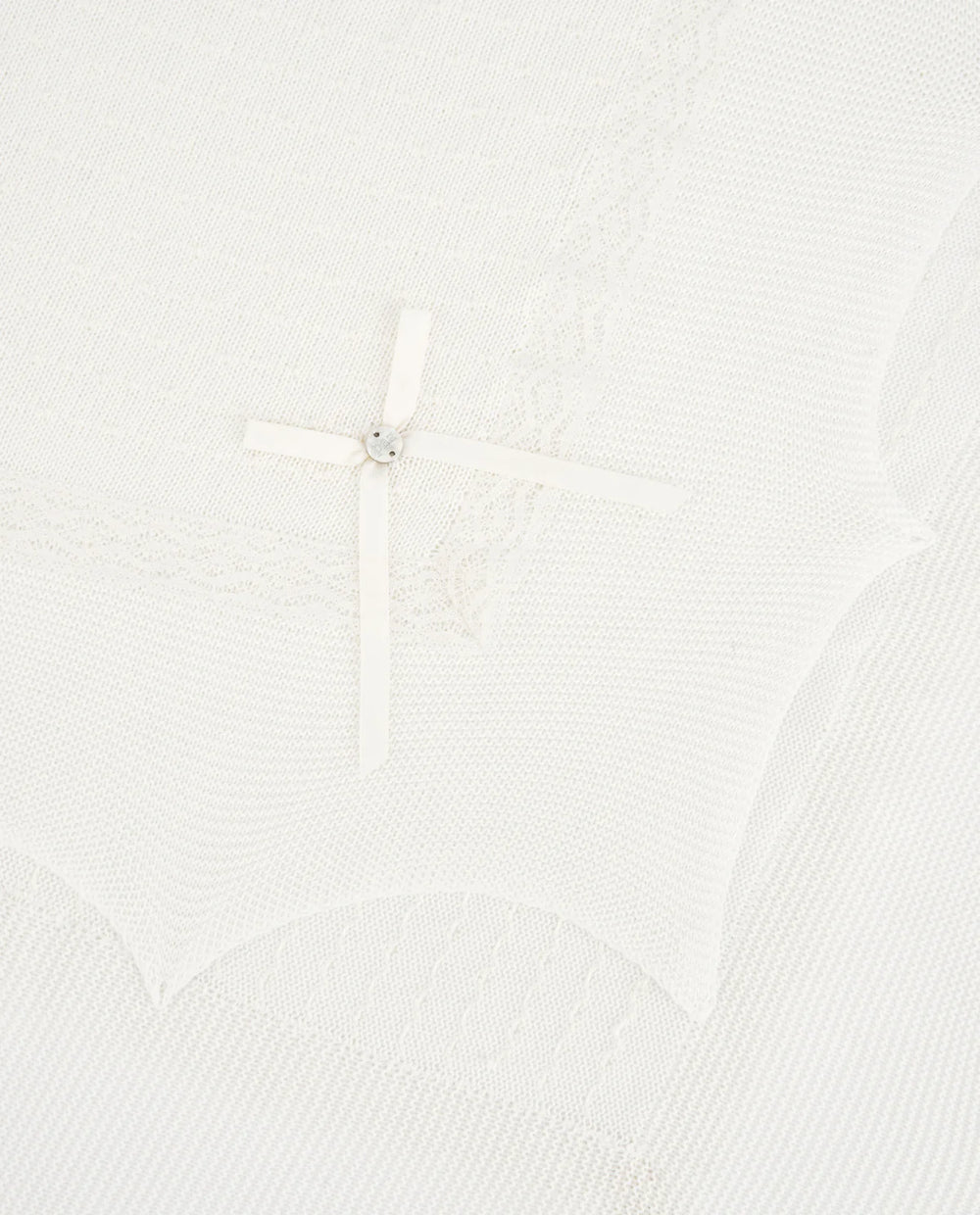 Close up of lace detail of an ivory baby blanket