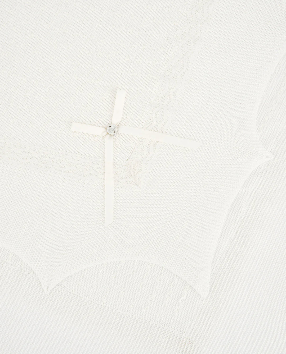 Close up of lace detail of an ivory baby blanket