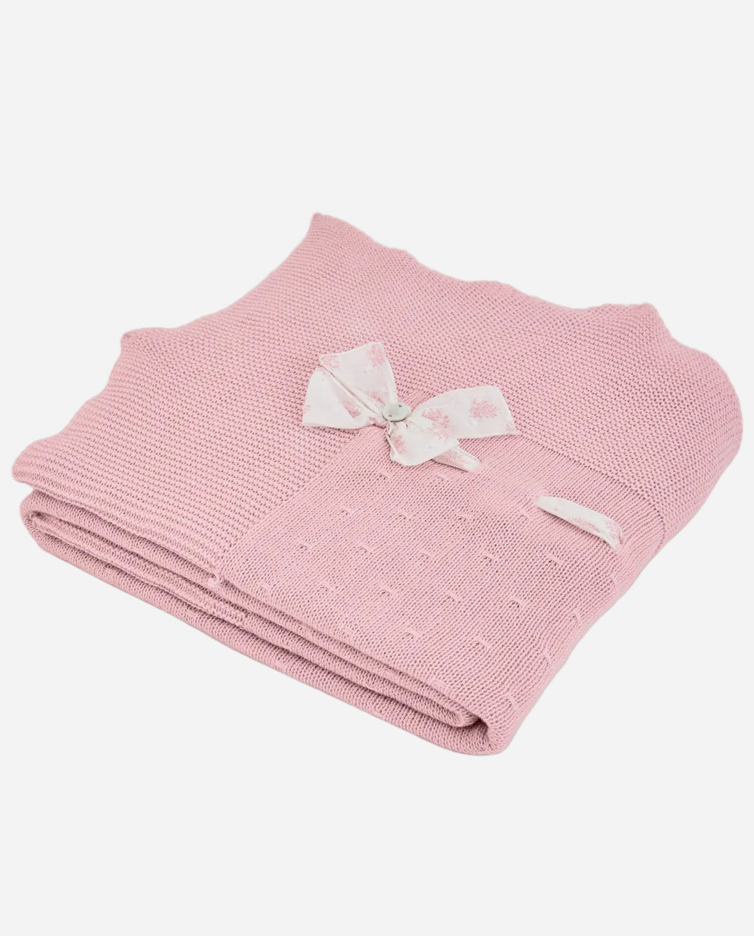 Pink knitted blanket with a white bow on a light gray background