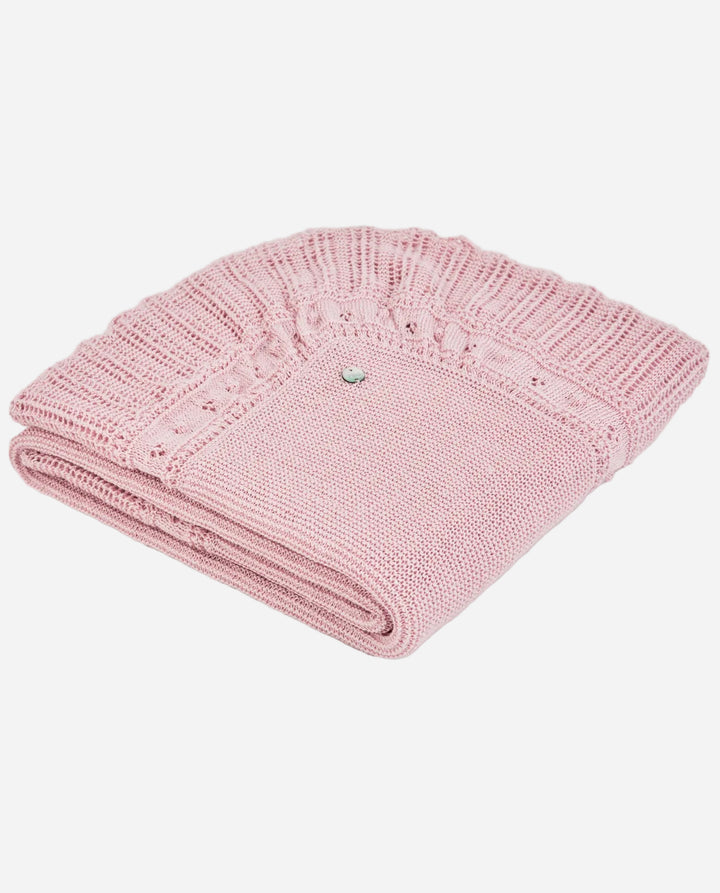 Folded pink knitted blanket on a light gray background
