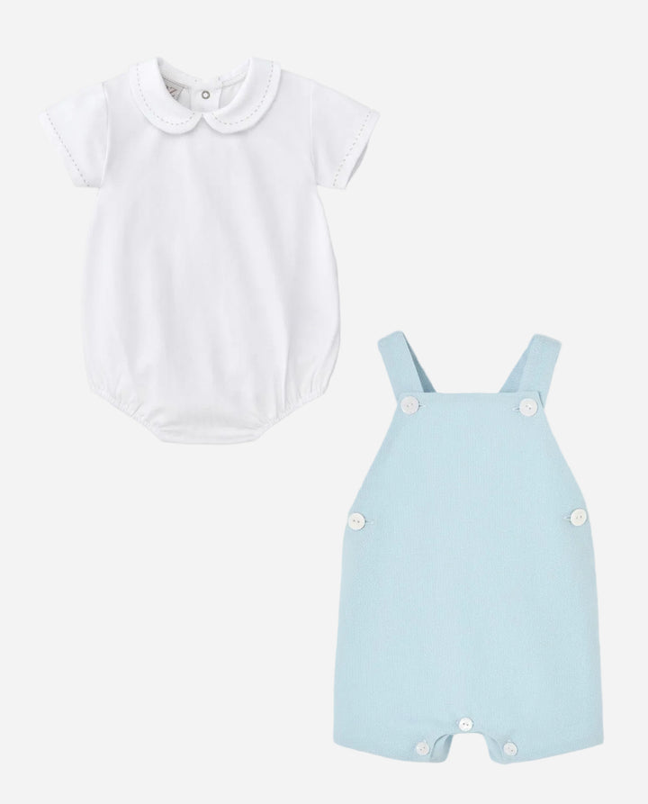 White shirt with Peter Pan collar and light blue overalls on a gray background