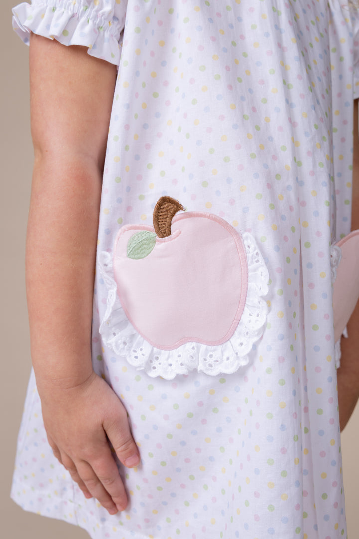 Details of a girls bitty print dress with apples