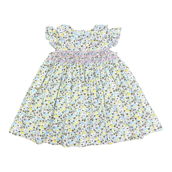 A baby girl's dress with a white background, a dense yellow, blue, and gray floral print, ruffled cap sleeves, and a smocked waistband.