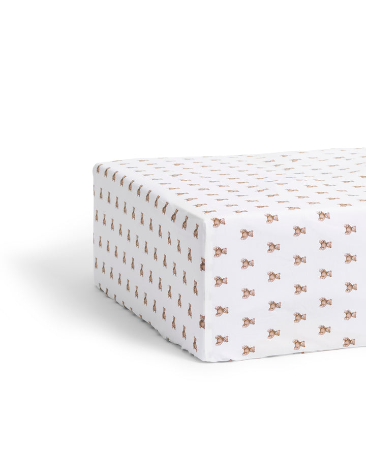 Fitted crib sheet with a teddy bear pattern on a white background